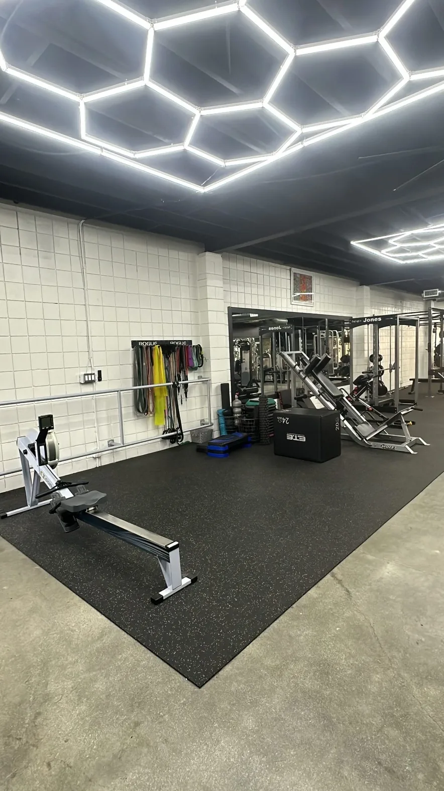 Functional training zone with rower, resistance bands wall, plyo boxes and hack squat at BASIC Training