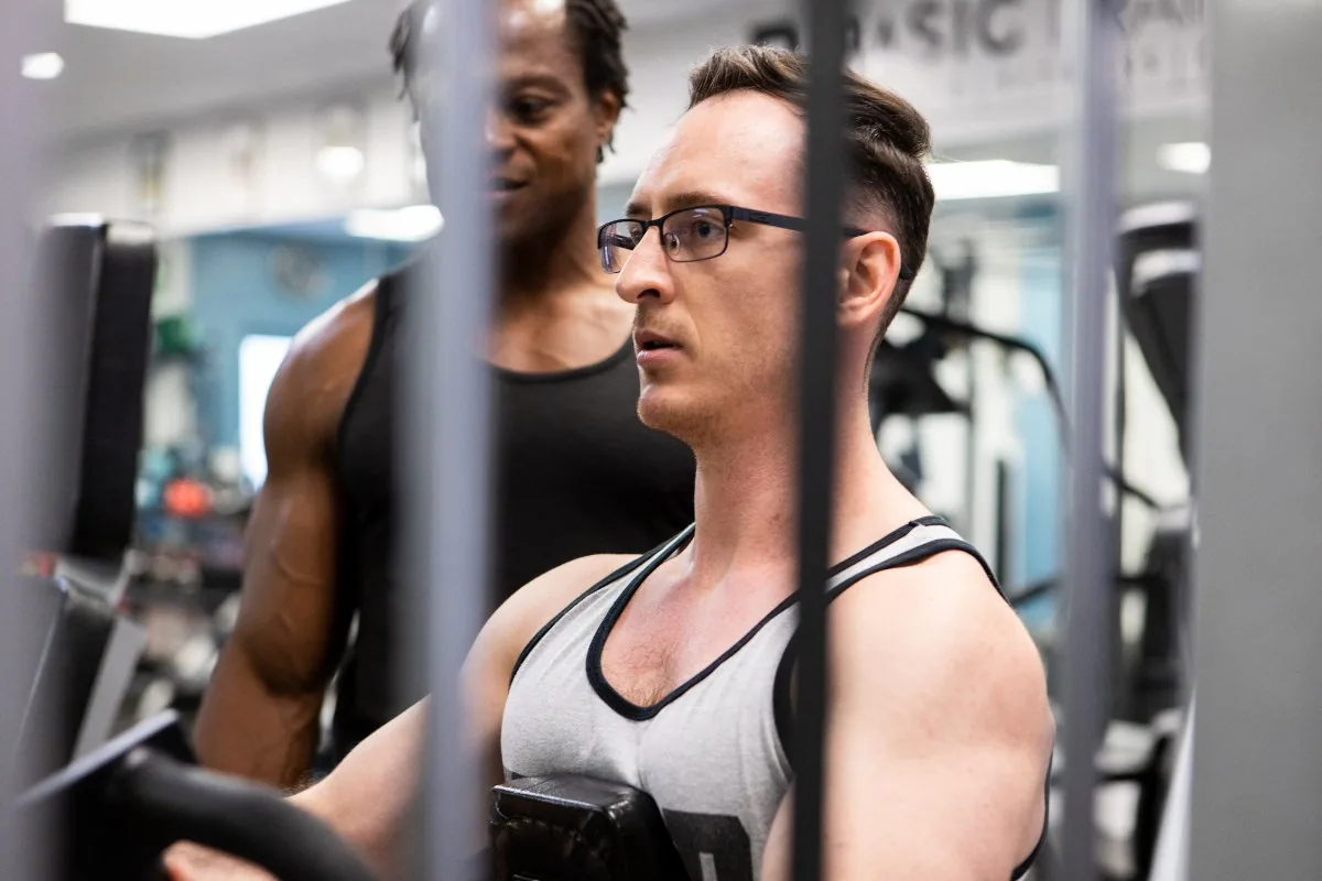 Personal trainer coaching a client through a machine exercise